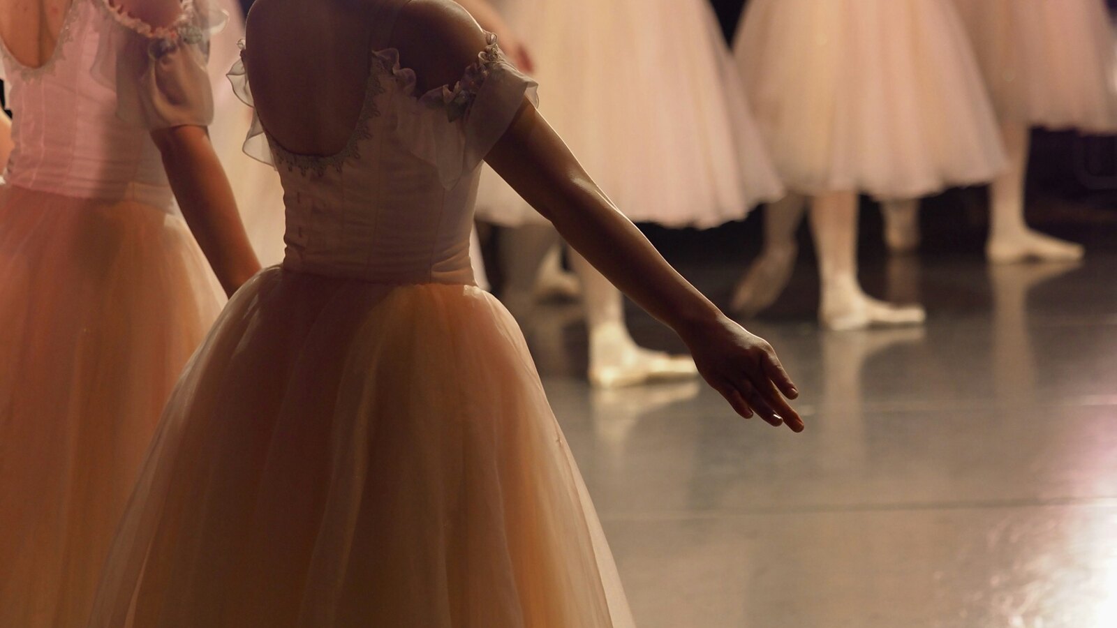 Ballet dancers rehearsing together in a warm studio